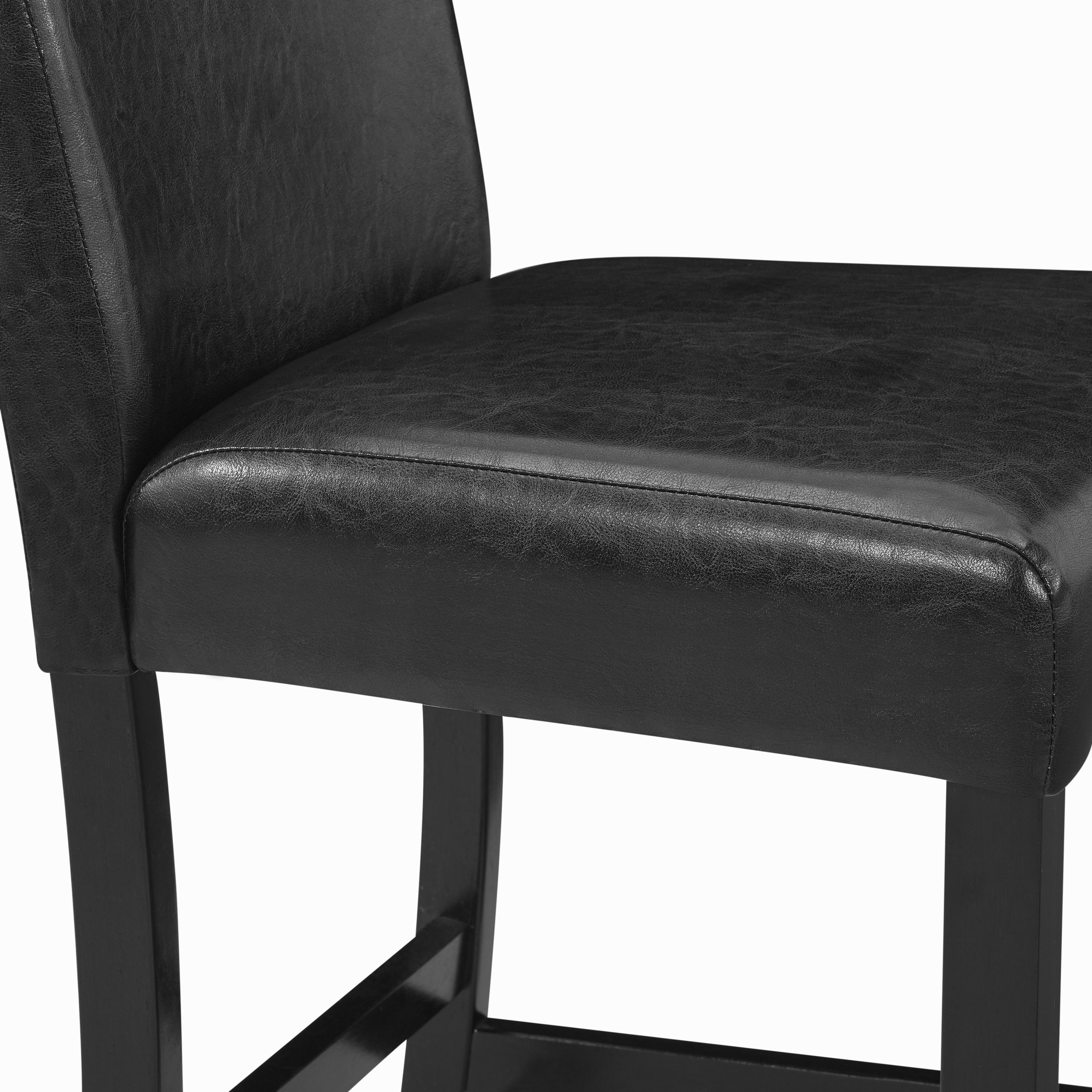 A close-up of the #1715PU "Lennon" Faux Marble Top Counter-Height Dining Set shows a black faux leather chair with a cushioned seat and backrest, supported by dark wooden legs.