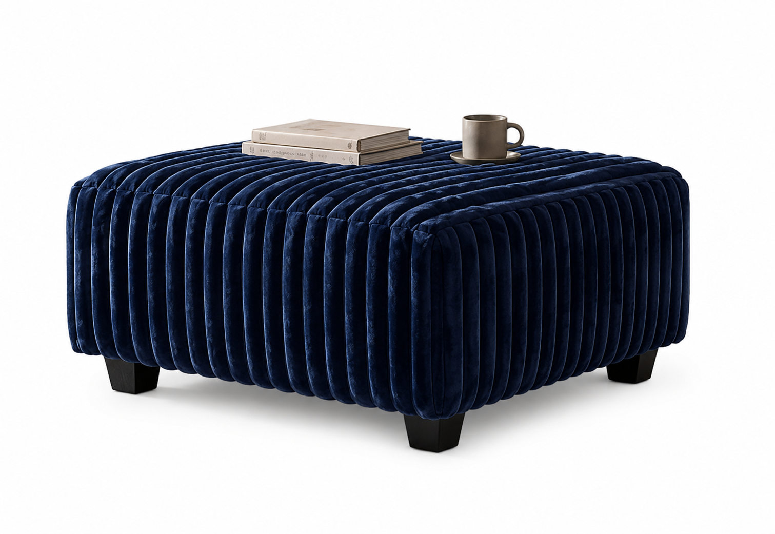 The #4250 Square Ottoman, upholstered in navy blue velvet with tufted detailing and vertical stitching, stands on four black legs. A stack of books and a gray mug rest on its plush surface against a plain white background.