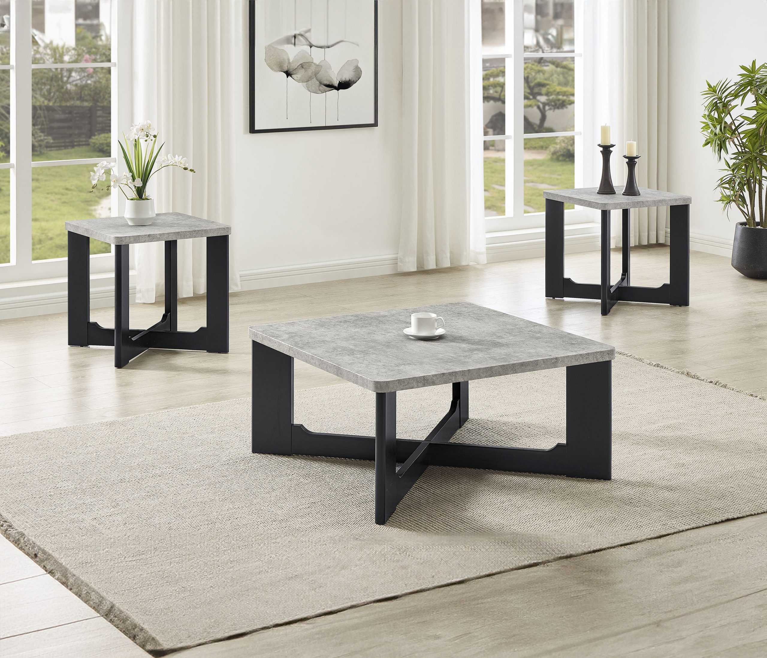 The "Royce" Set (#4130) features grey-black coffee tables with stone tops and sleek legs on a large beige rug, accented by decorative items, white curtains, and stylish wall art in a modern living room.